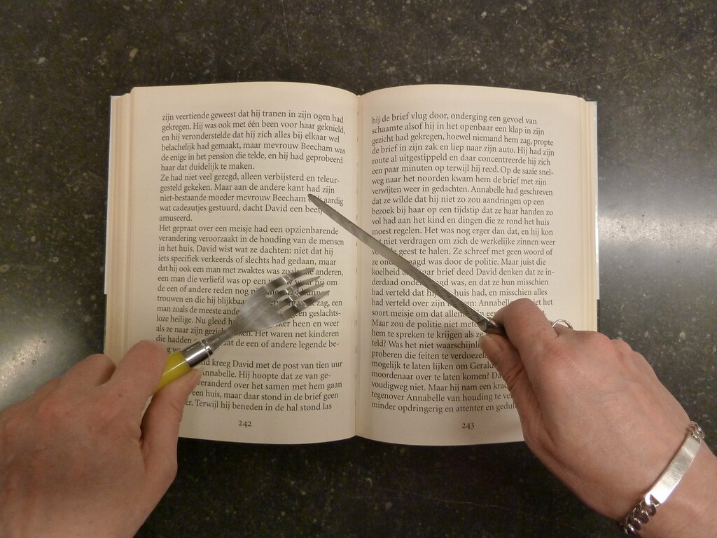 Boek waar boven handen met een mes en een vork