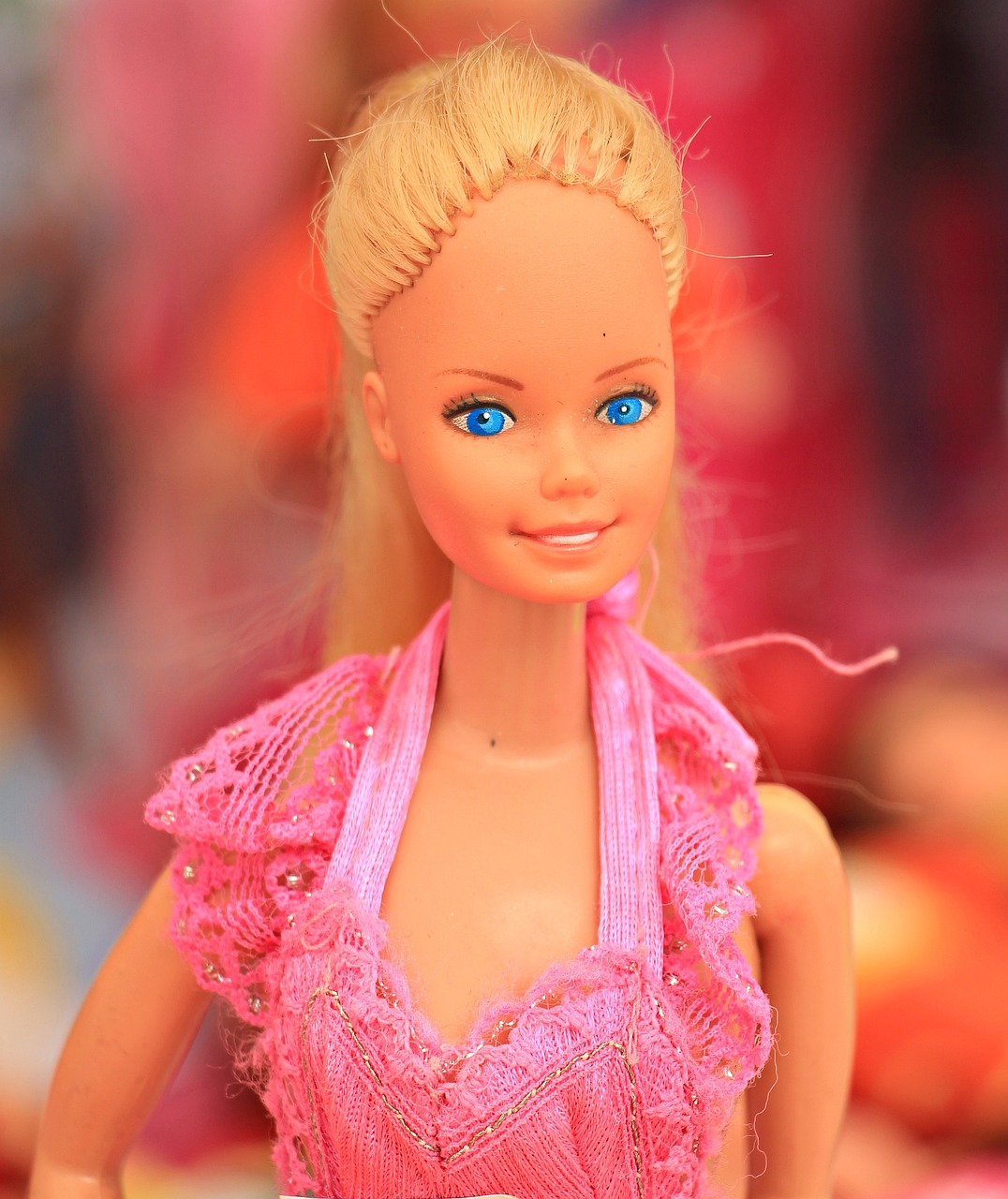 Buste-afbeelding van barbie, blond opgestoken haar, knalroze, kanten jurk(-bovenstuk)