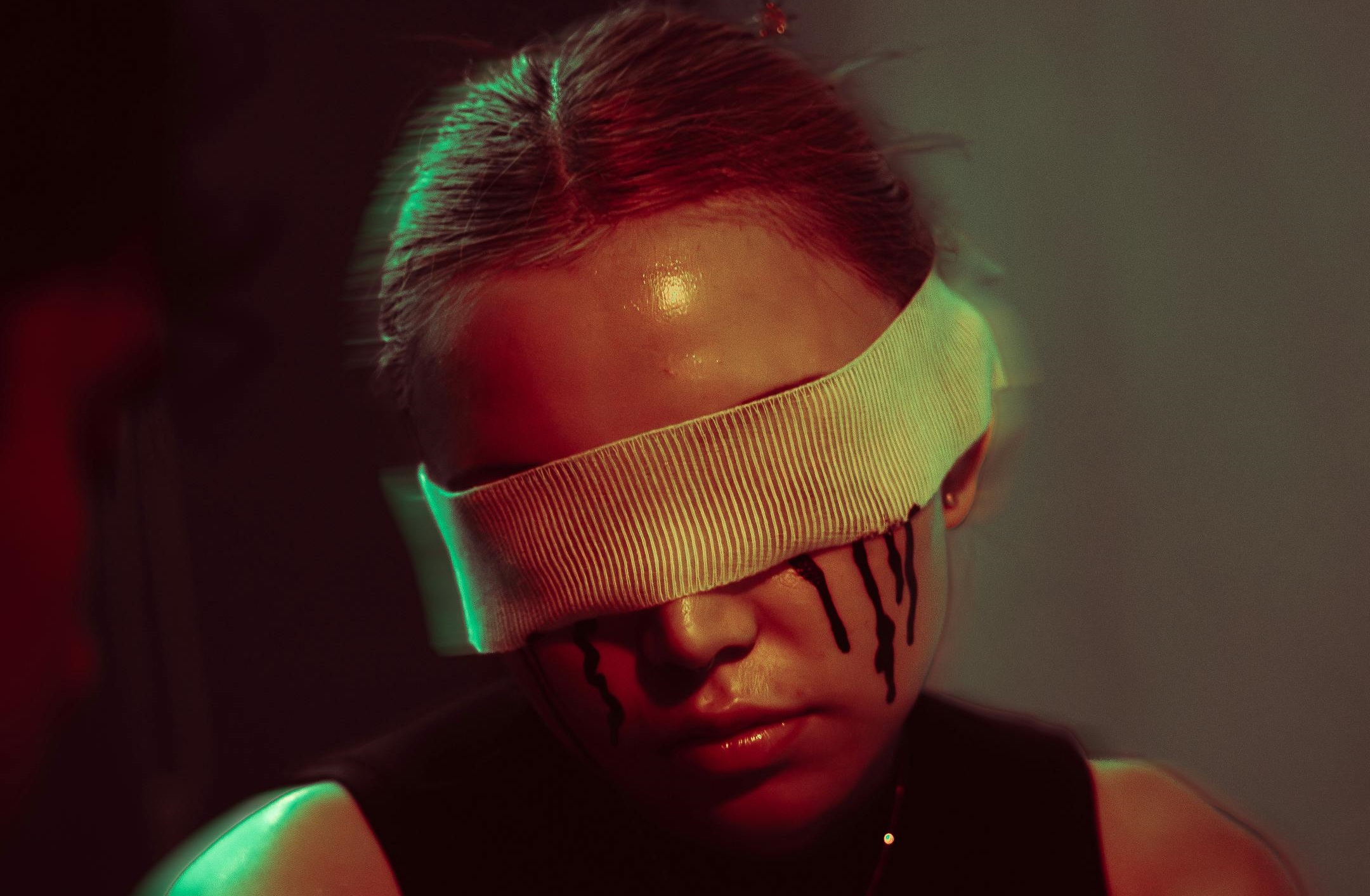 Vrouw met gaas om haar ogen huilt donkere tranen