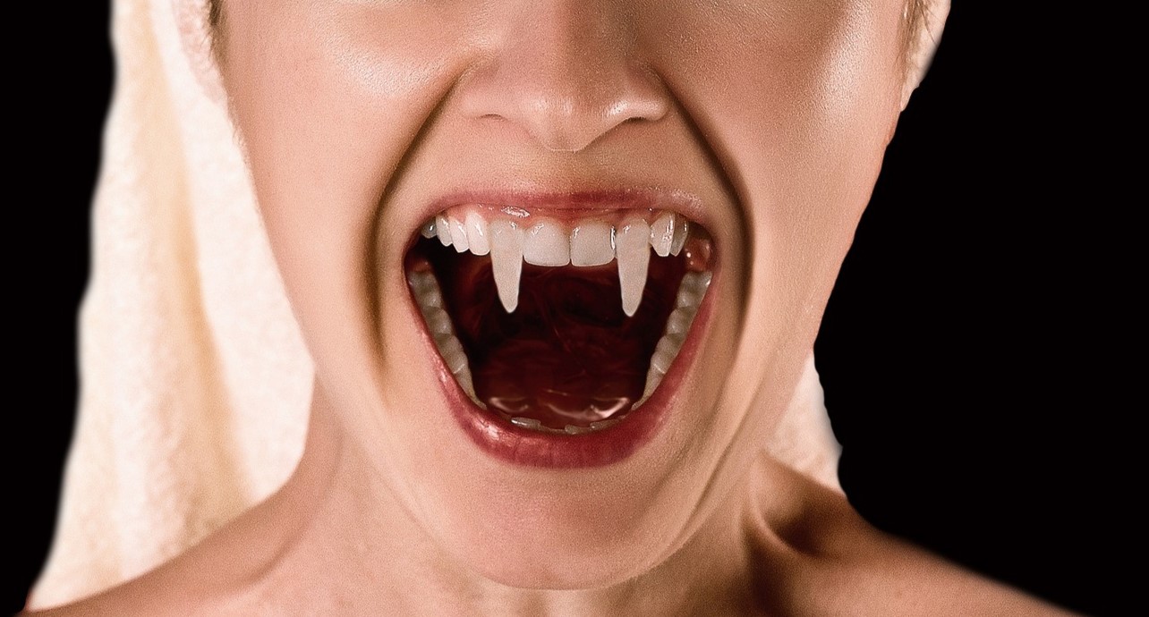 Vrouw opent mond en toont haar vampierentanden
