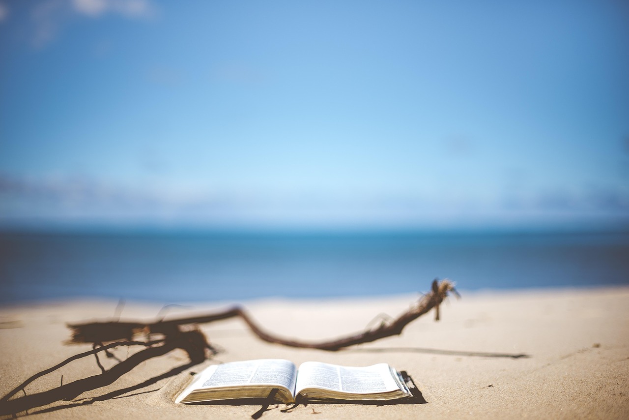 Een boek ligt open op een strand