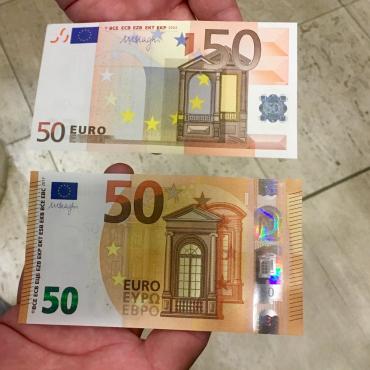 Oud en nieuw 50-eurobiljet samen op een handpalm