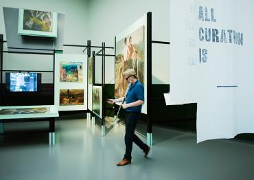 Ontwerper Simon Dogger loopt met een proefversie van Tik-tik door een museumzaal