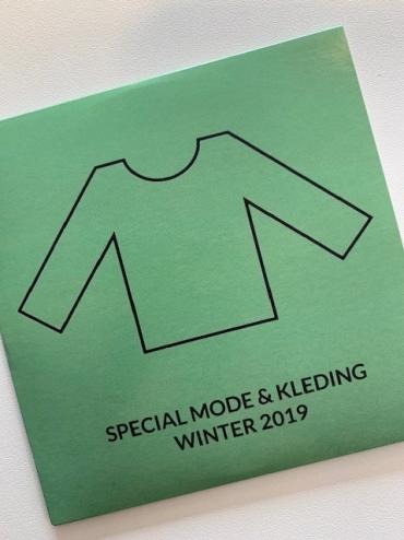 Groen hoesje van Winterspecial-cd met titel daarop en omtrek van een trui met lange mouwen