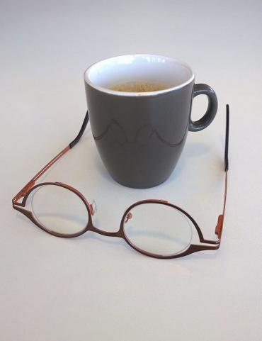 Logo Zienswijs: beker koffie met omgekeerde bril ervoor op tafel