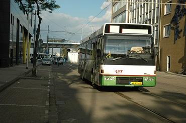 straat omgeven door gebouwen waarover een bus aan komt rijden