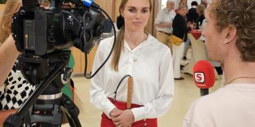 Tjarda Struik tegenover een camera en verslaggever met microfoon