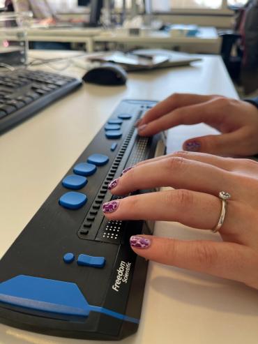 twee handen op een braille toetsenbord
