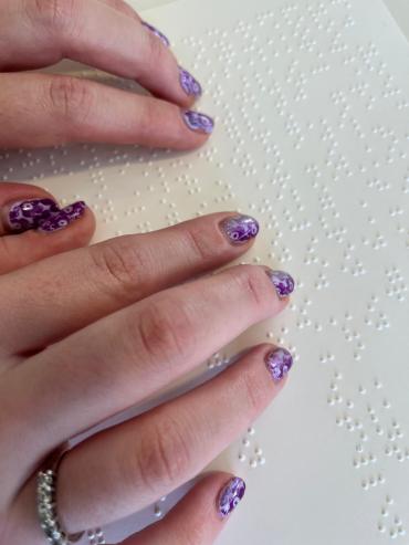 Vingers die op een vel met braille rusten.