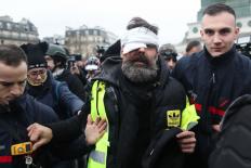 Franse demonstrant Jérôme Rodrigues, met verband om zijn hoofd, aan beide kanten ondersteund