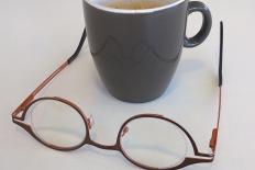 Zienswijslogo: omgekeerde bril voor beker koffie