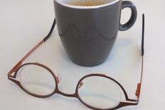 Logo Zienswijs: beker koffie met omgekeerde bril ervoor op tafel
