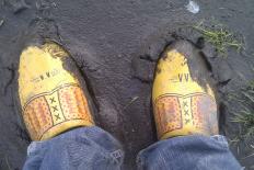 voeten met klompen aan in de modder