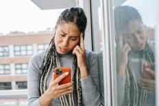 Moeilijk kijkende vrouw met telefoon in haar hand