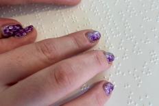 Vingers die op een vel met braille rusten.