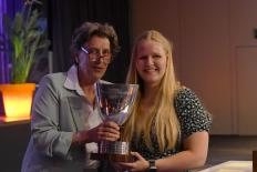 Liesette Bruinsma met NOC*NSF-voorzitter Anneke van Zanen-Nieberg, samen houden ze een trofee vast